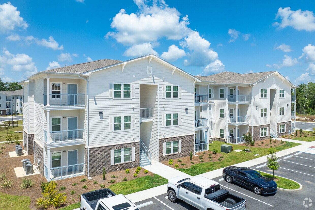 Three-story Spartan Ridge buildings with lap siding over a brick water table