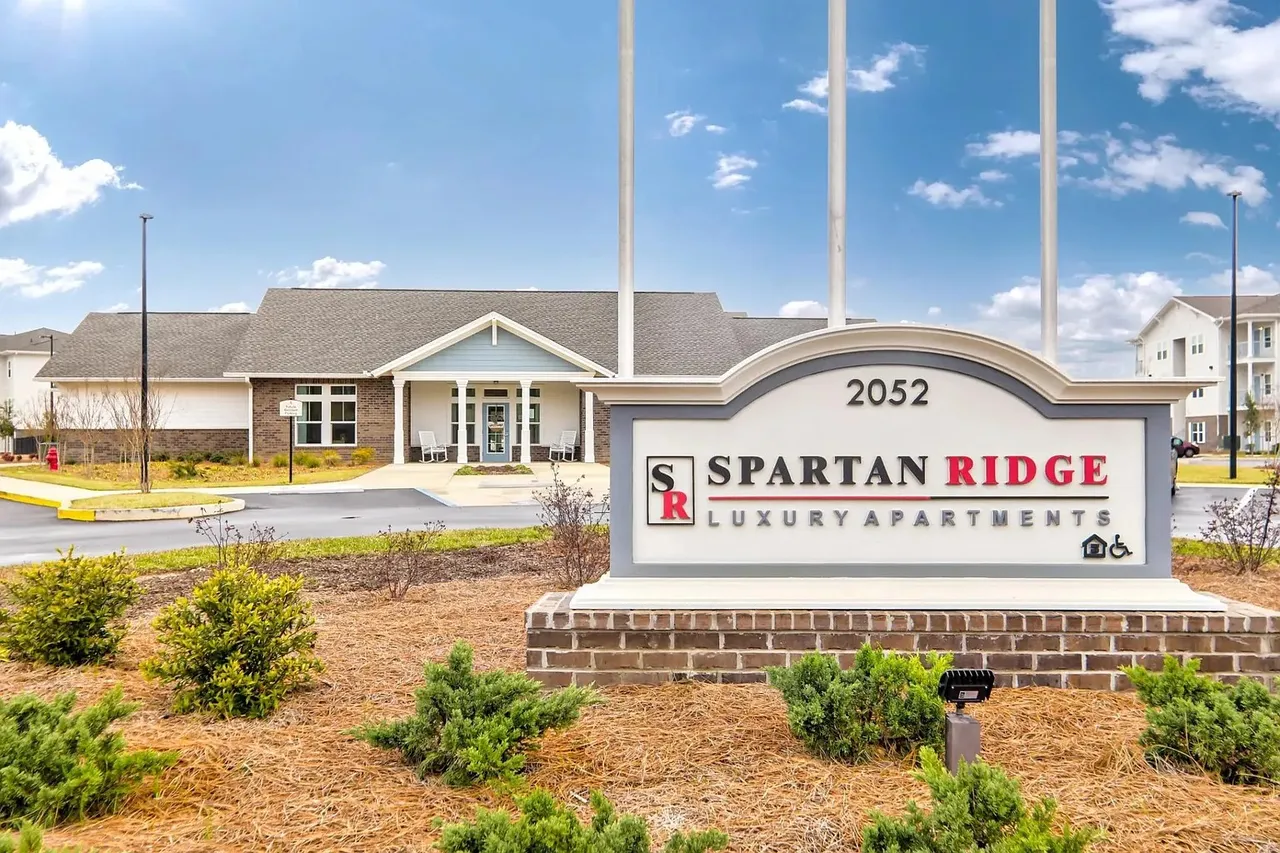 Spartan Ridge entrance sign with the clubhouse behind